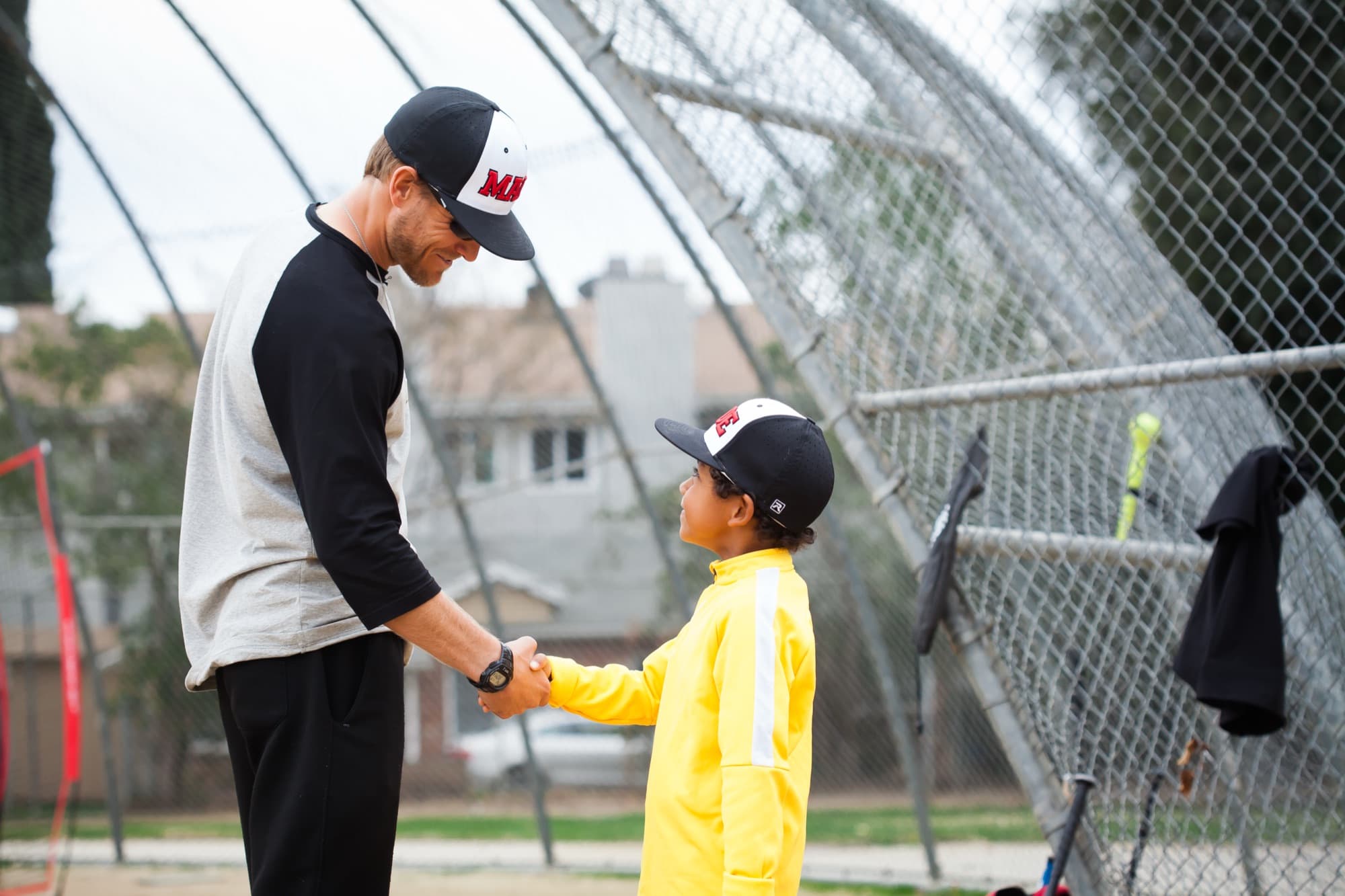 Coach Isaac Hess shaking hands with a young player after a lesson